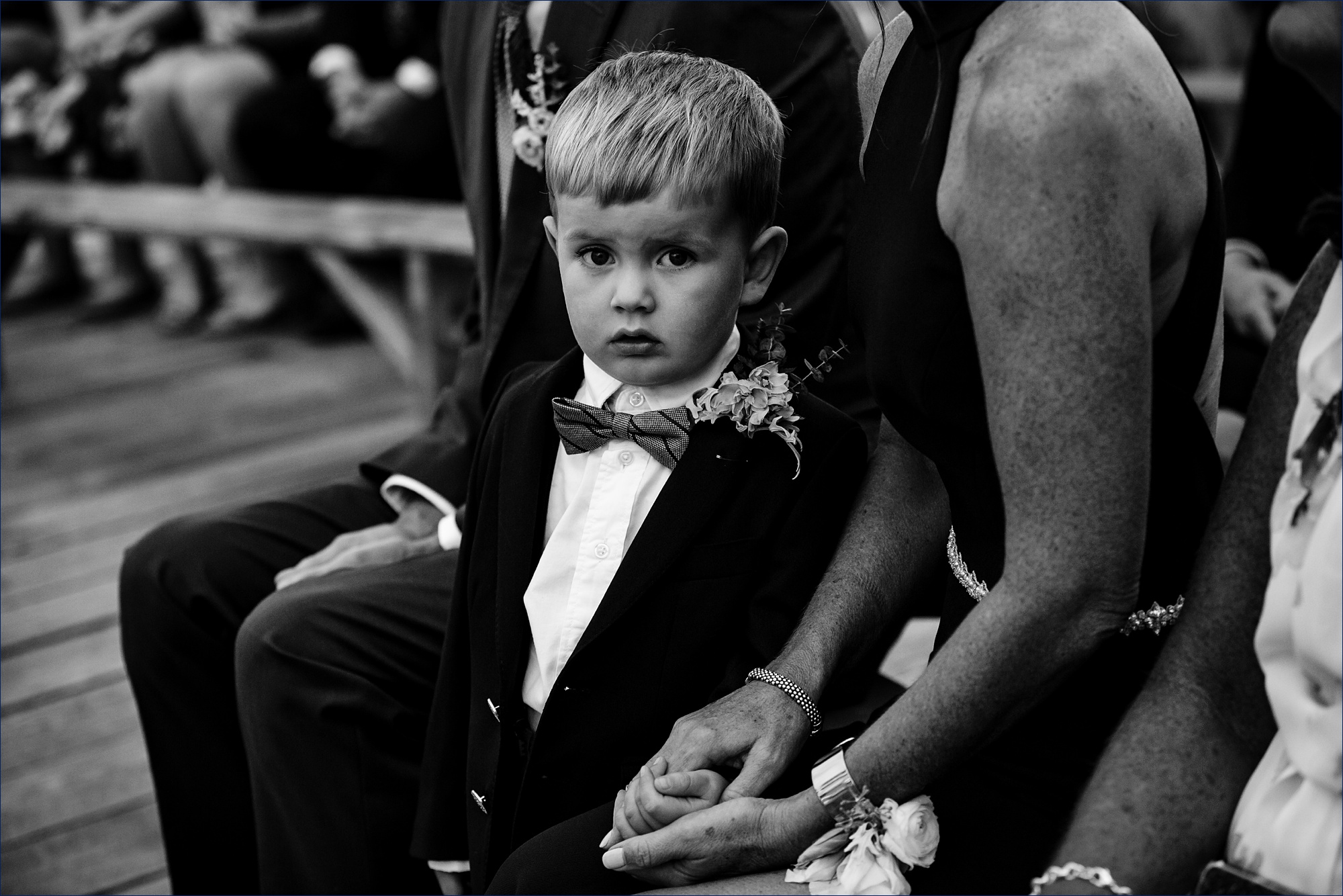 The son of the couple watches the action of the wedding ceremony with his grandmother
