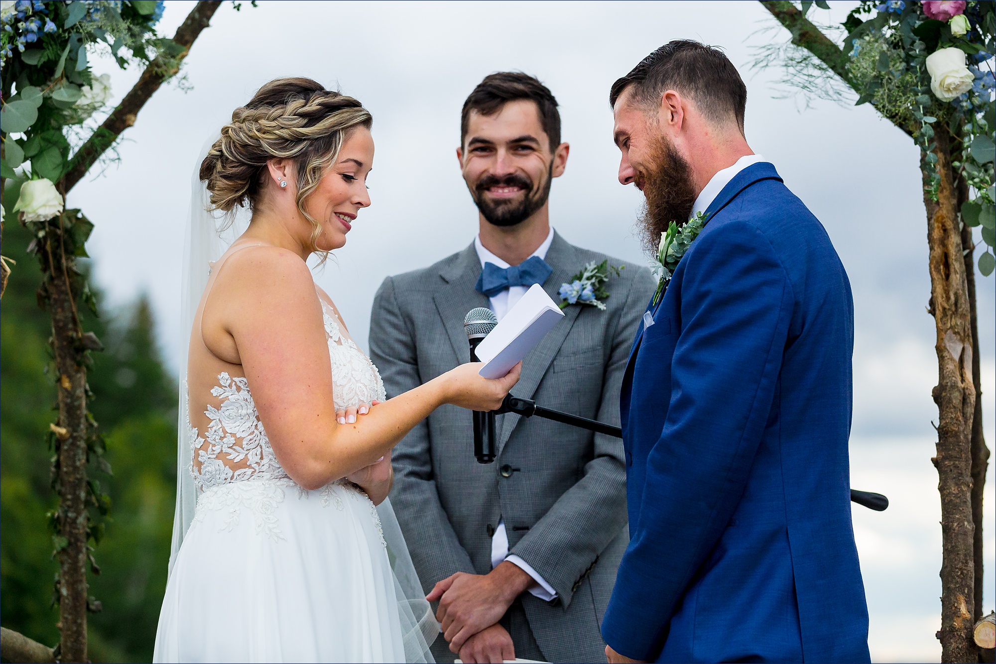 The bride reads her vows to her husband while her brother smiles warmly