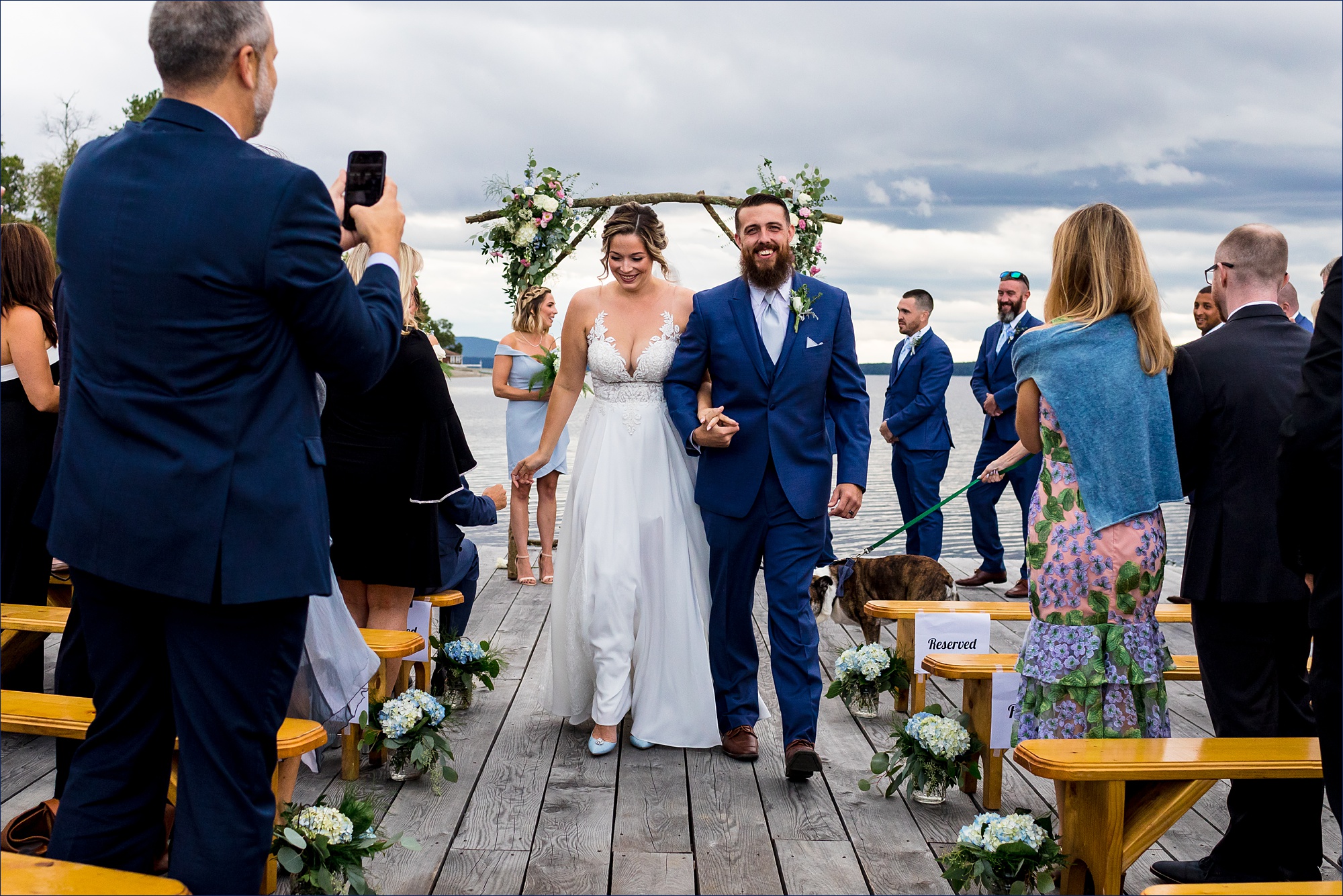 The newly married couple walks back up the dock after being officially married in Maine