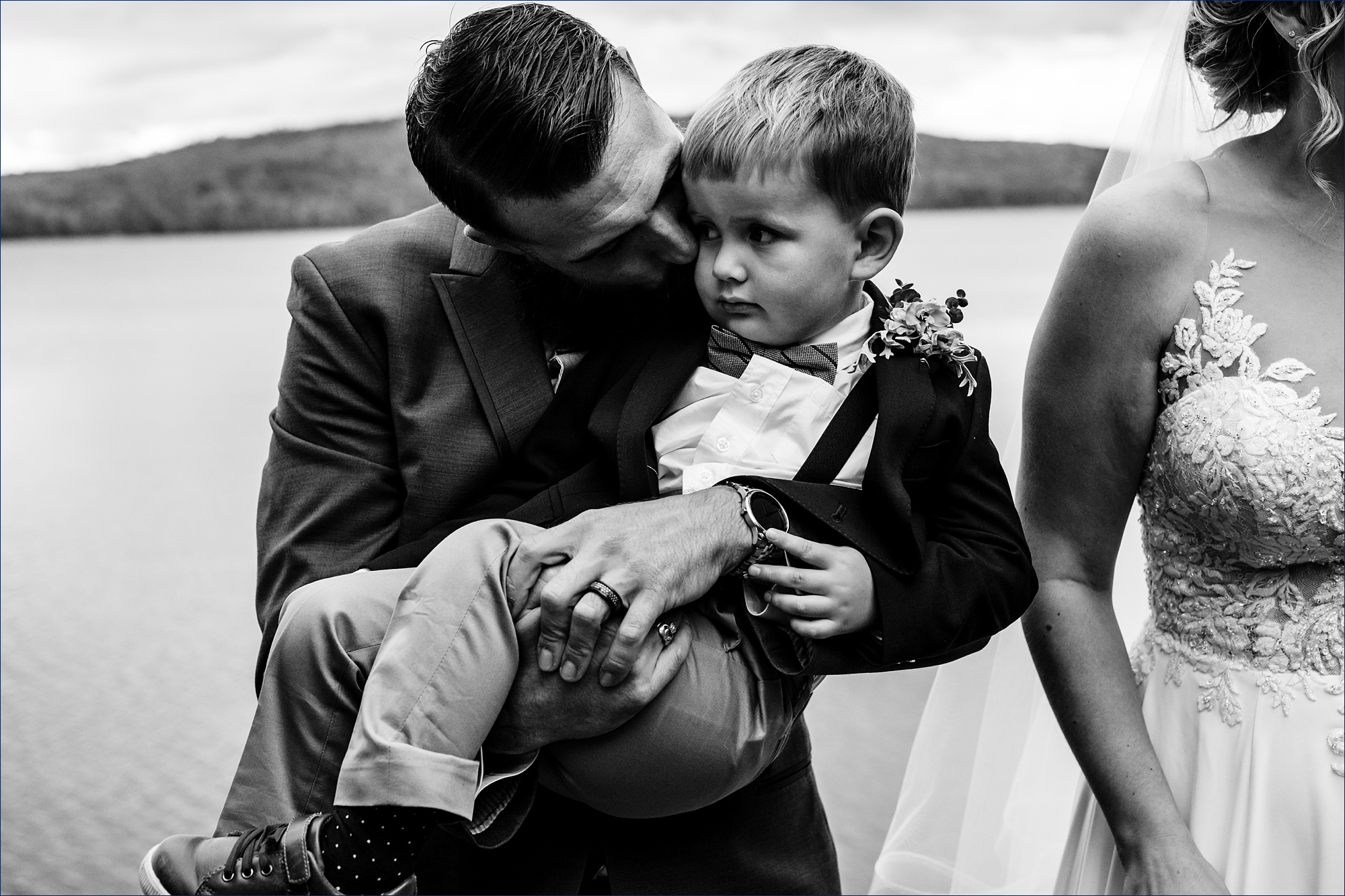 The groom snuggles his son after he marries his wife in Maine