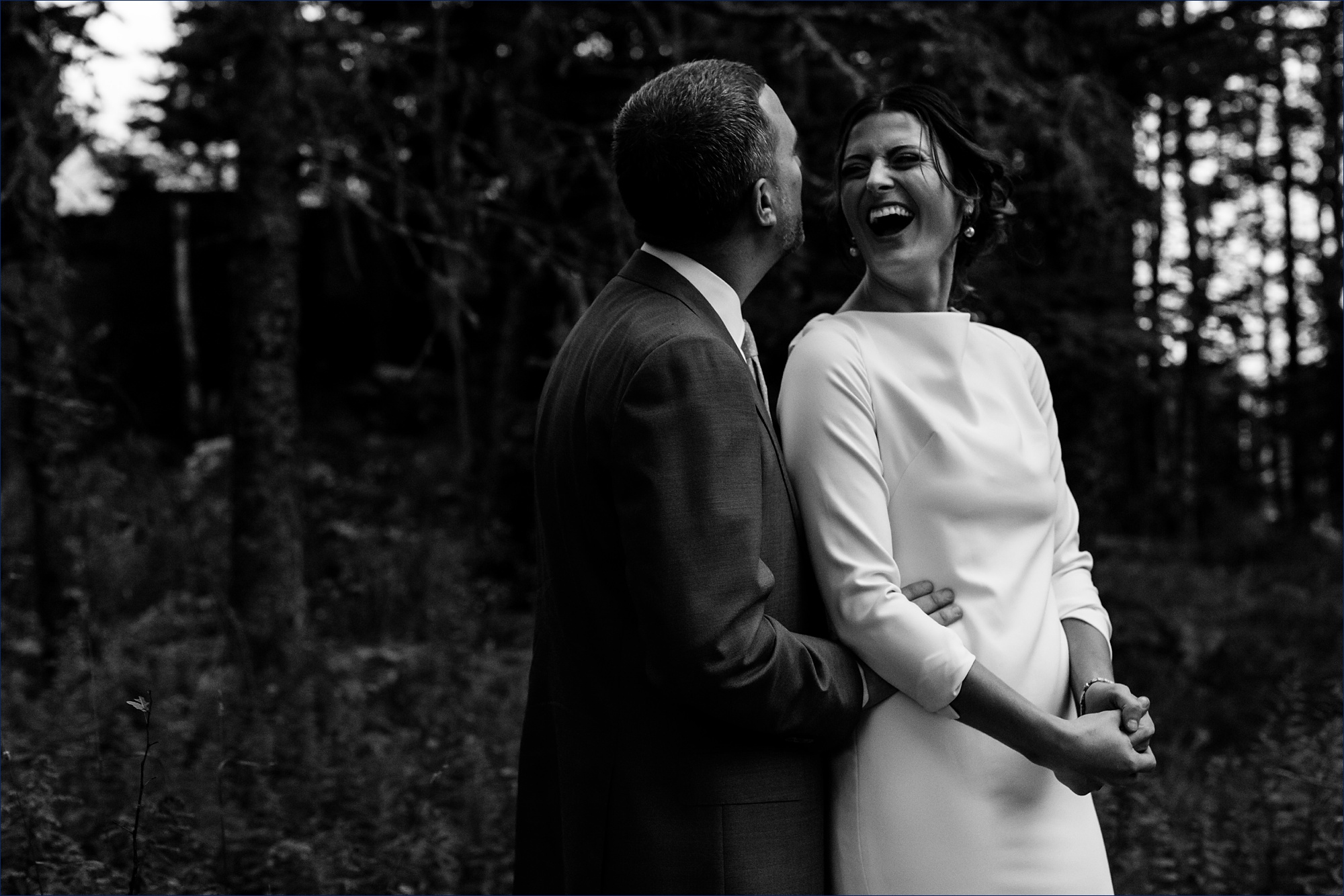 The bride and groom laugh together in the woods of Little Cranberry Island Maine
