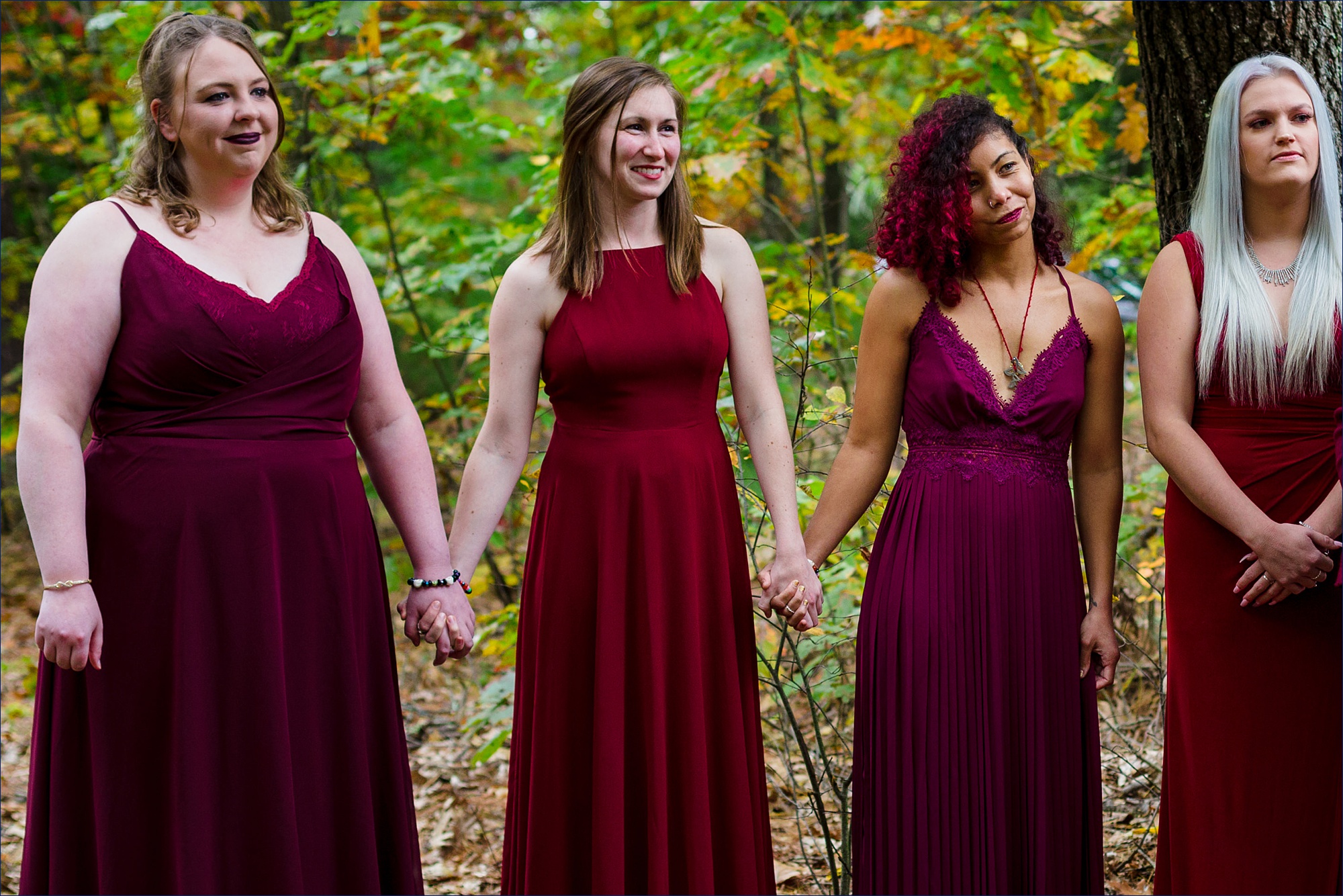 The bridesmaids hold hands as they watch the New Hampshire wedding in the fall take place