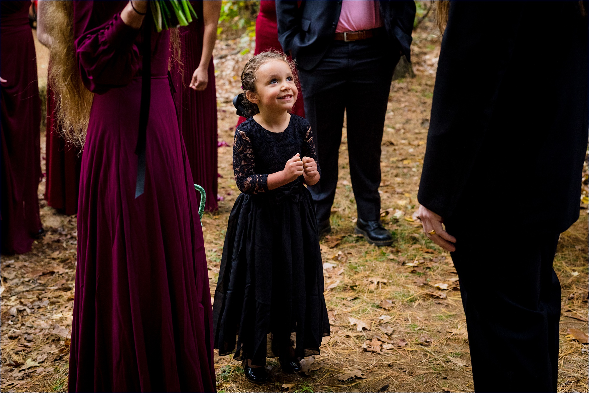 The bride's niece looks up at her new uncle on his wedding day with joy