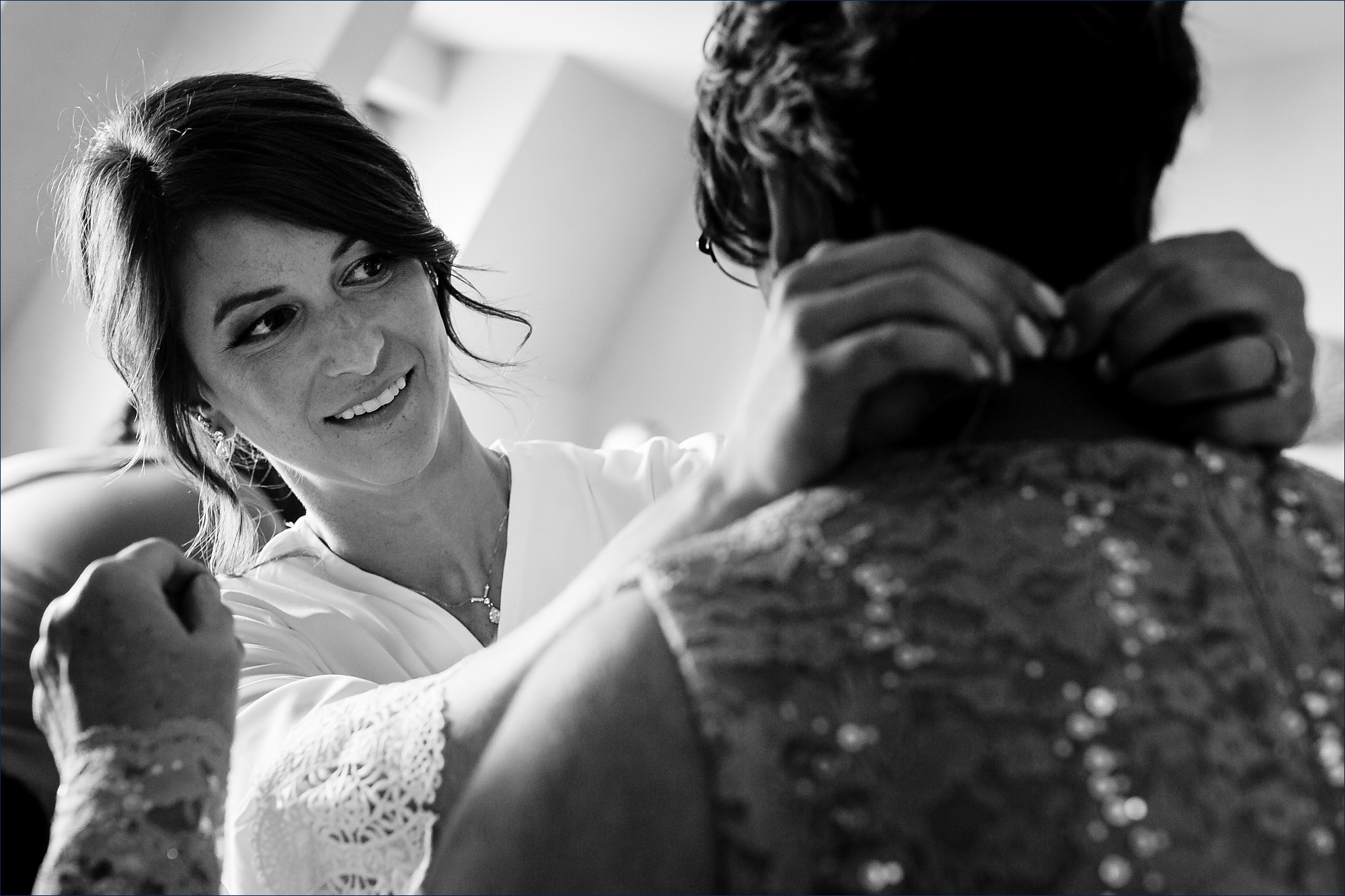 The bride gets her mom's necklace on while getting ready in Portsmouth NH