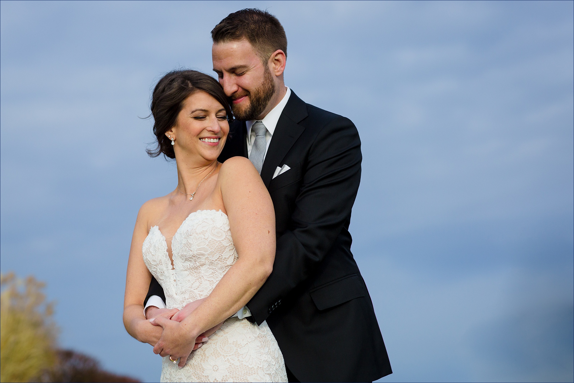 Beautiful Maine wedding day with the couple pictured against the stormy blue sky