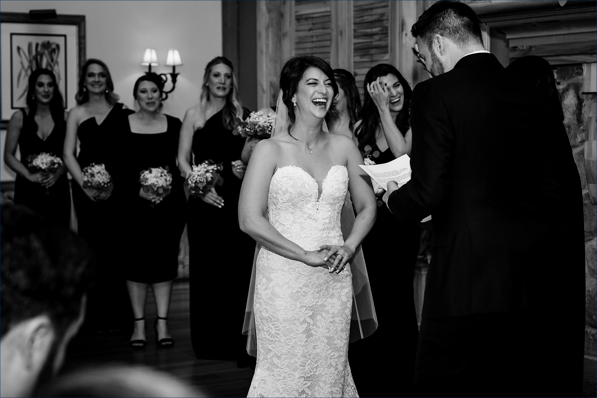 The bride laughs during the wedding ceremony in front of loved ones at their fall night wedding