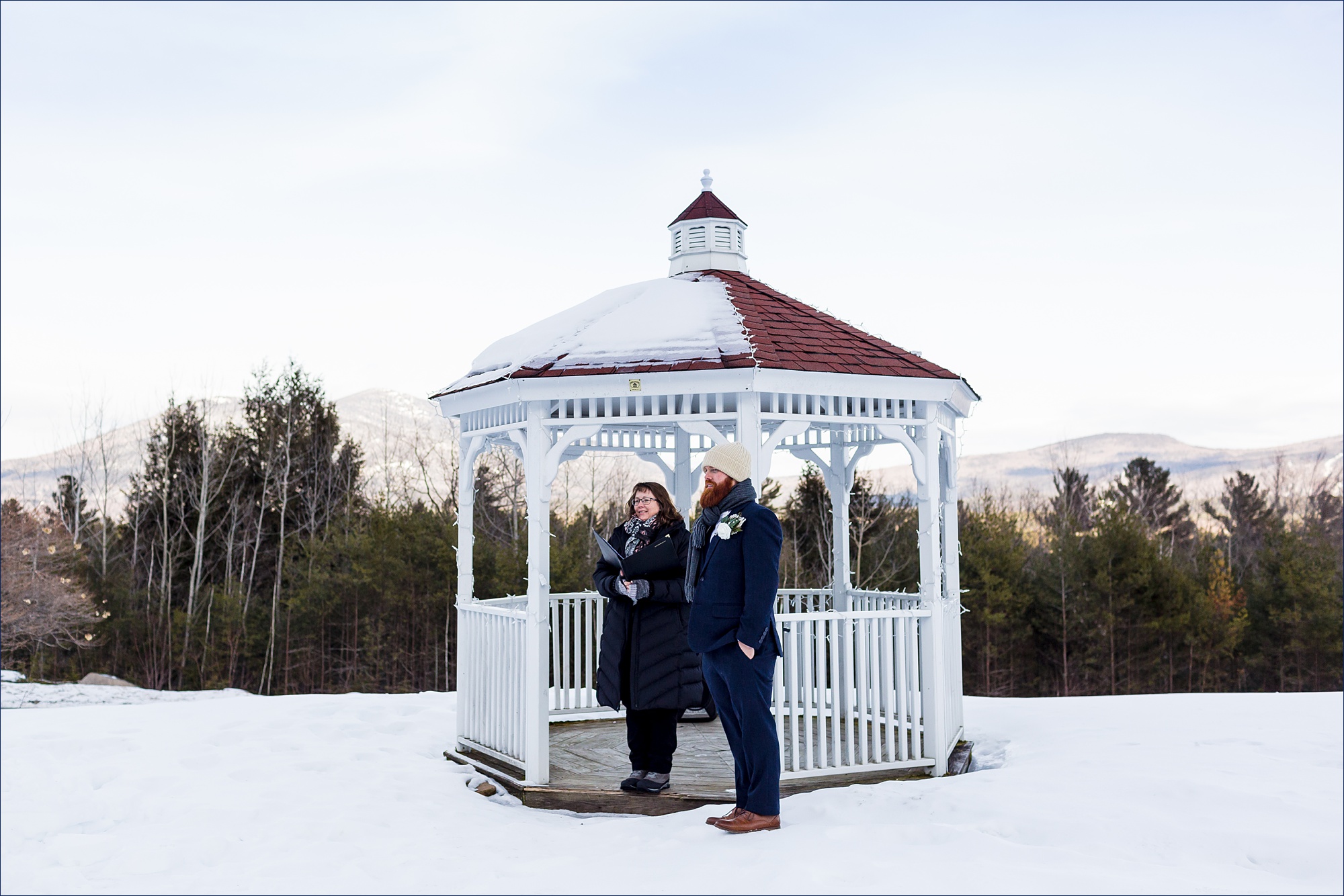 The groom awaits the bride for their outdoor winter elopement in New Hampshire's White Mountains