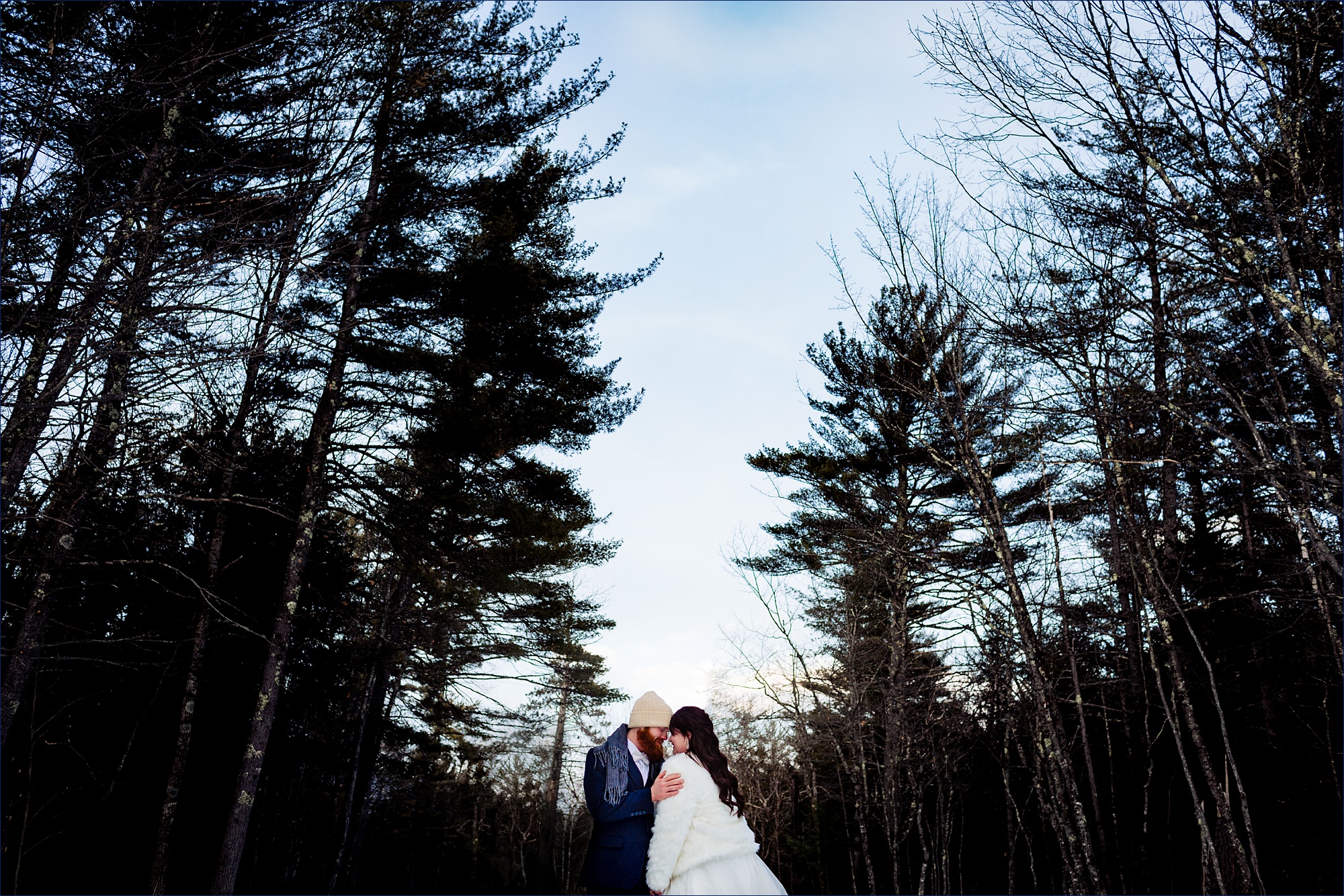 Echo Lake State Park Elopement NH the couple cuddles close in the winter in the woods