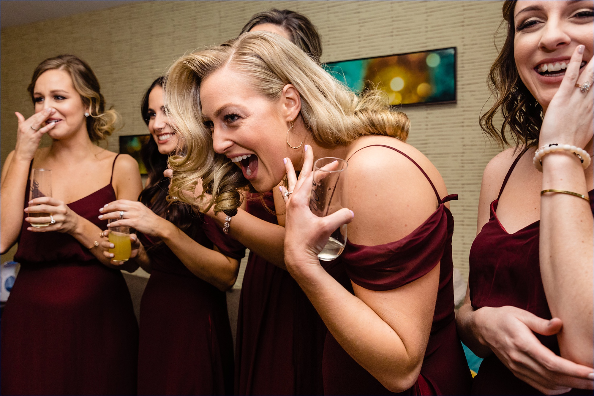 Bridesmaids celebrate seeing the bride in her dress for the first time