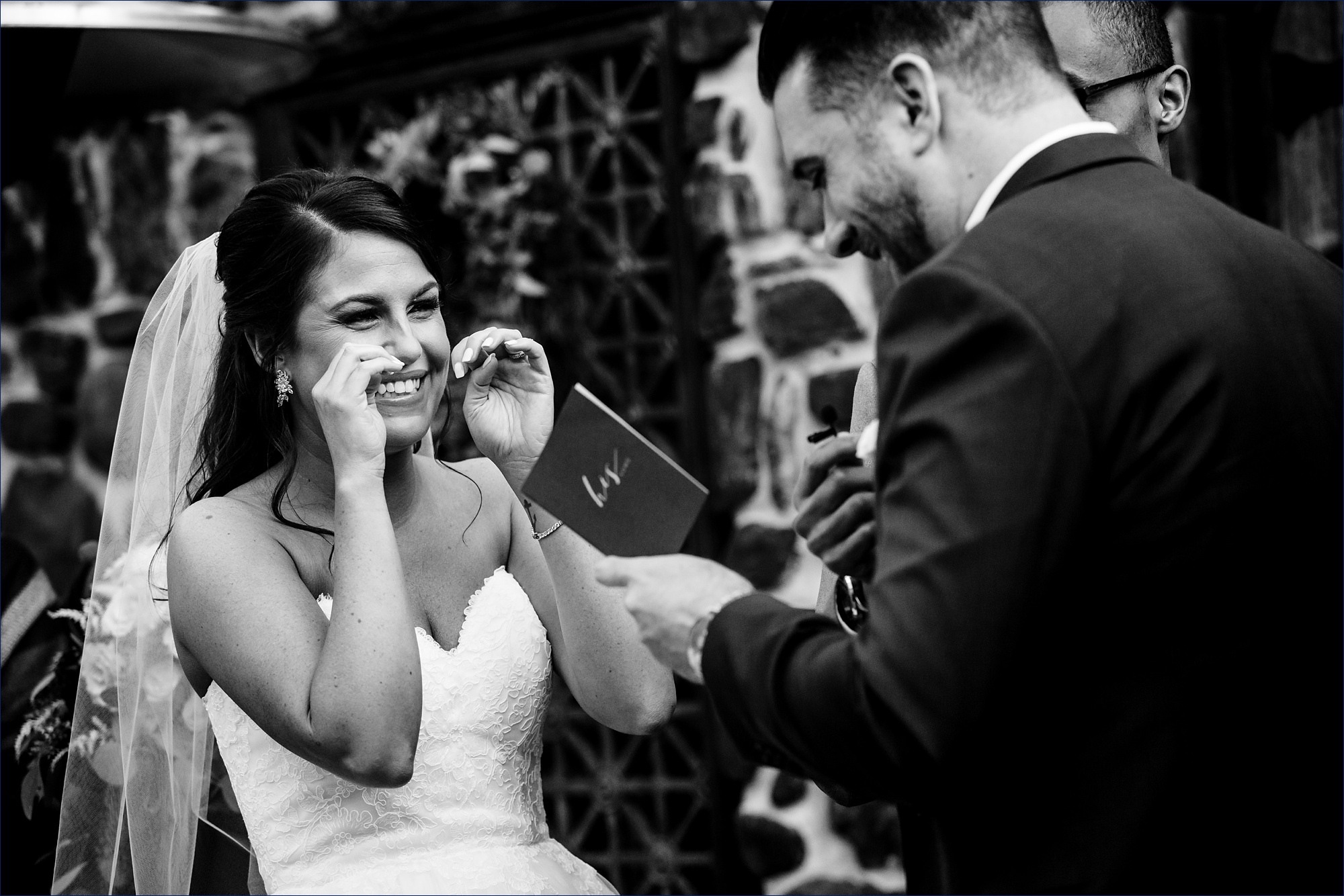 Bride laughs during the groom's vows to her on the wedding day