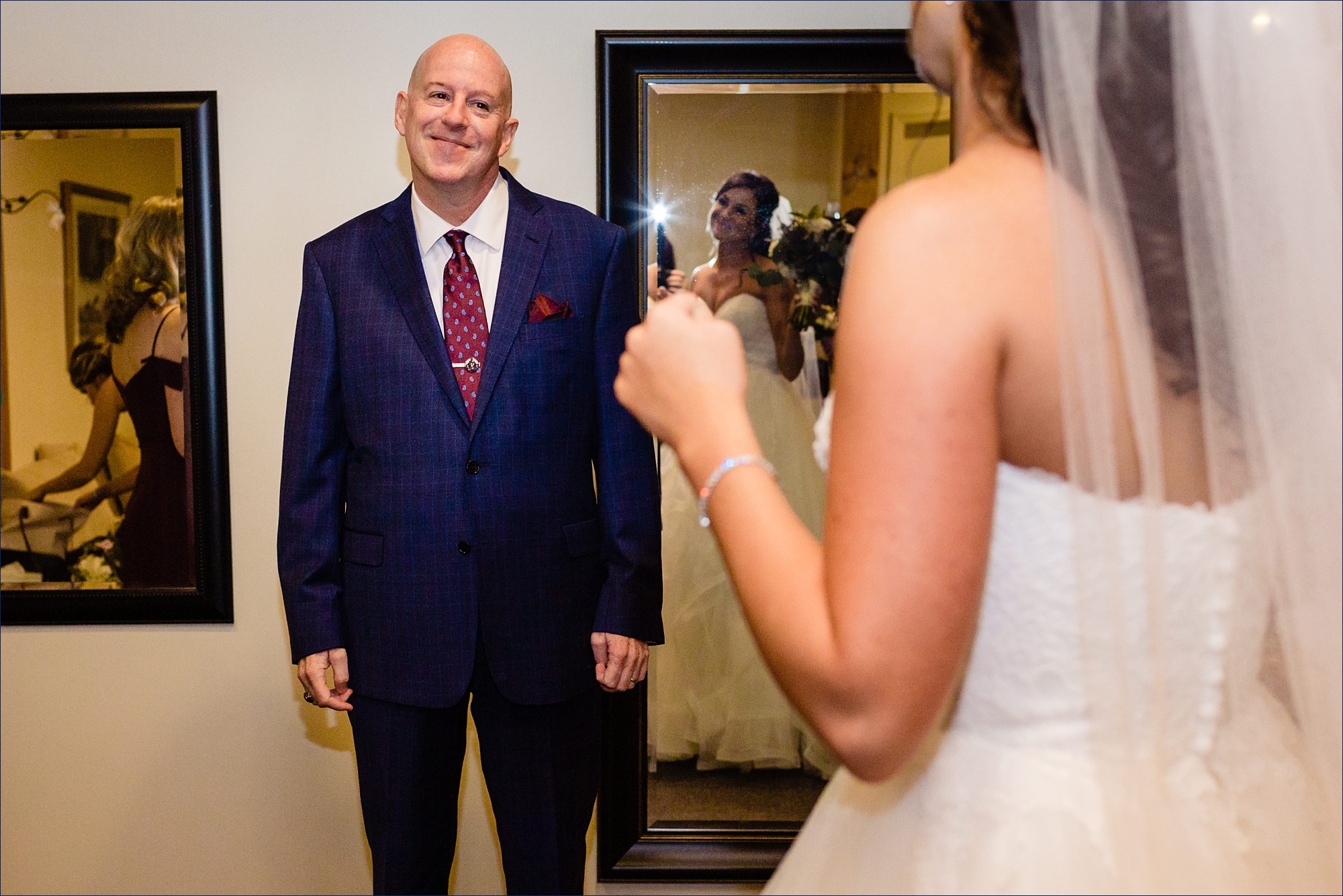 The bride does a first look with her father and he beams at her