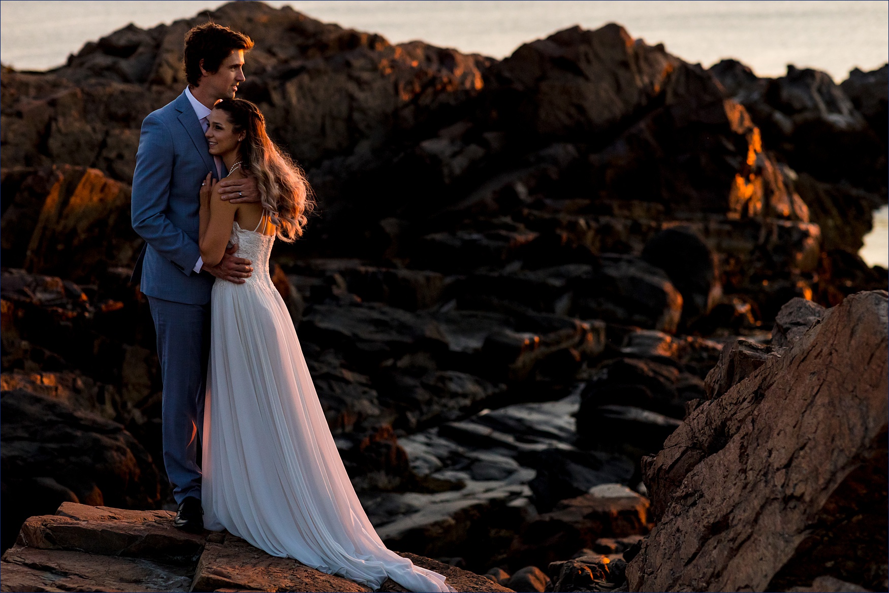 The bride and groom stand out on the Marginal Way rocks for the Maine elopement at sunrise