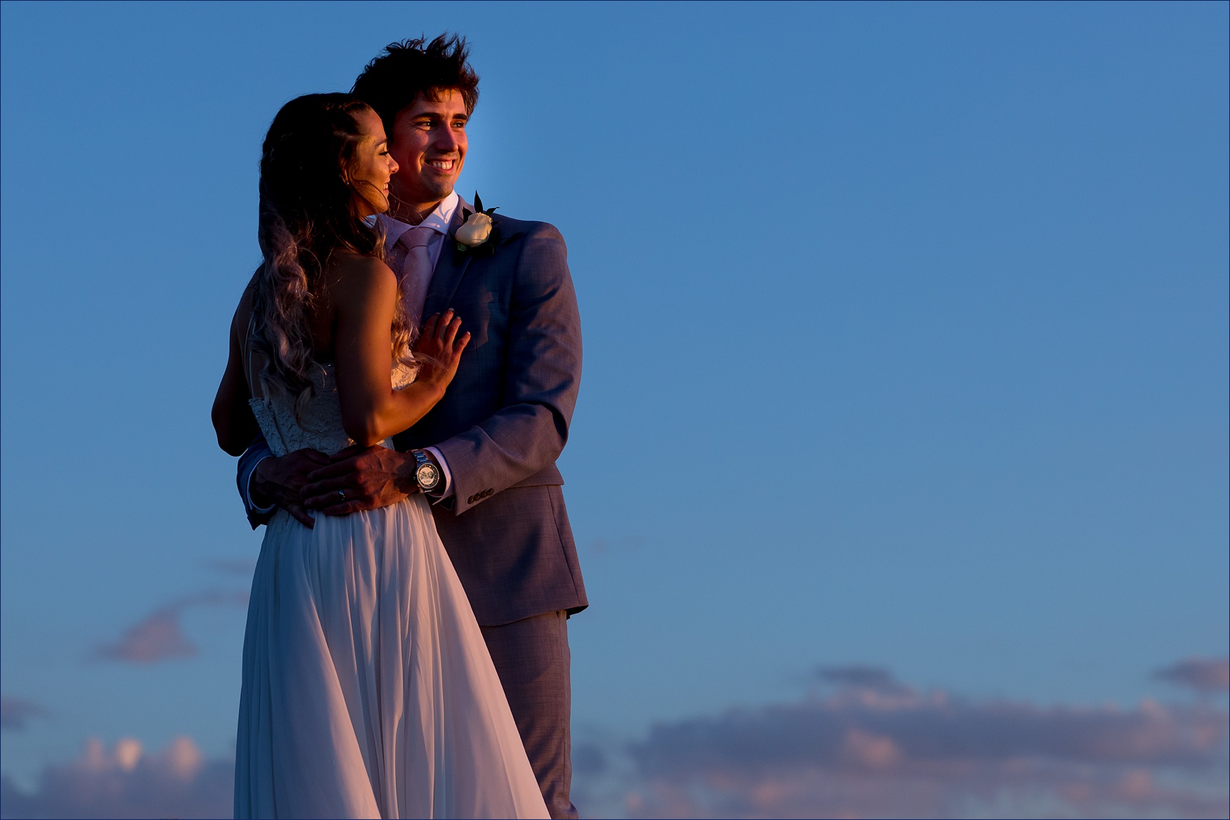 The bride and groom stand against a dark blue sky in Ogunquit Maine for their elopement
