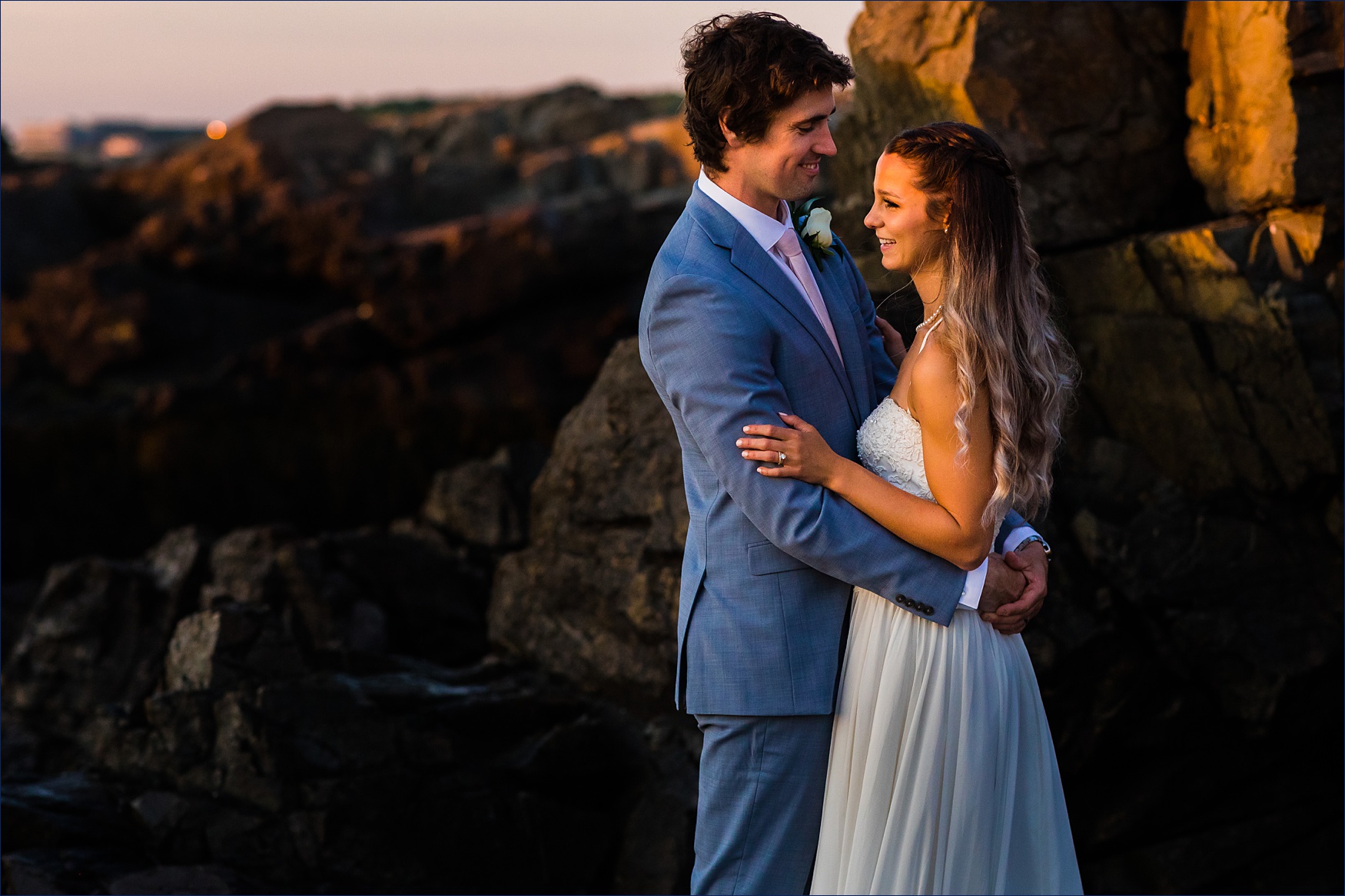 The bride and groom hold each other close while celebrating their sunrise Maine elopement