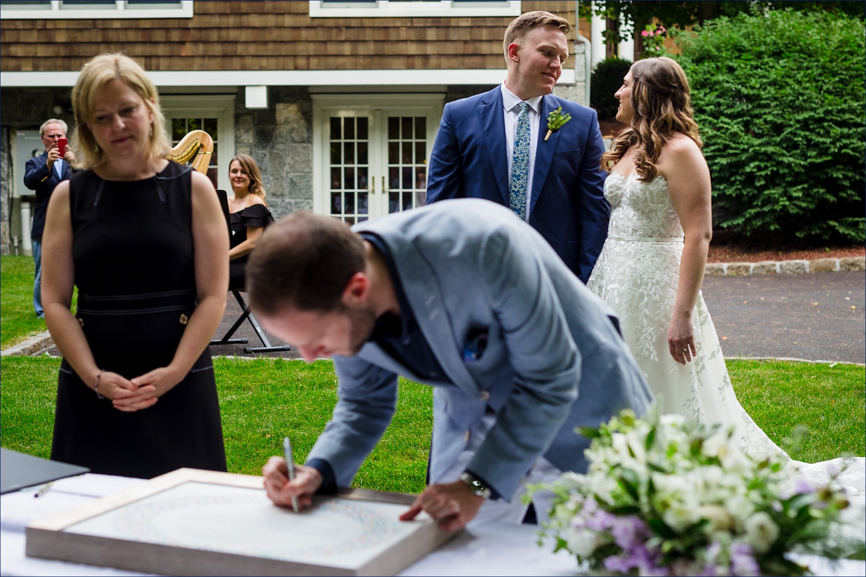The couple beams at one another at the signing of the Ketubah