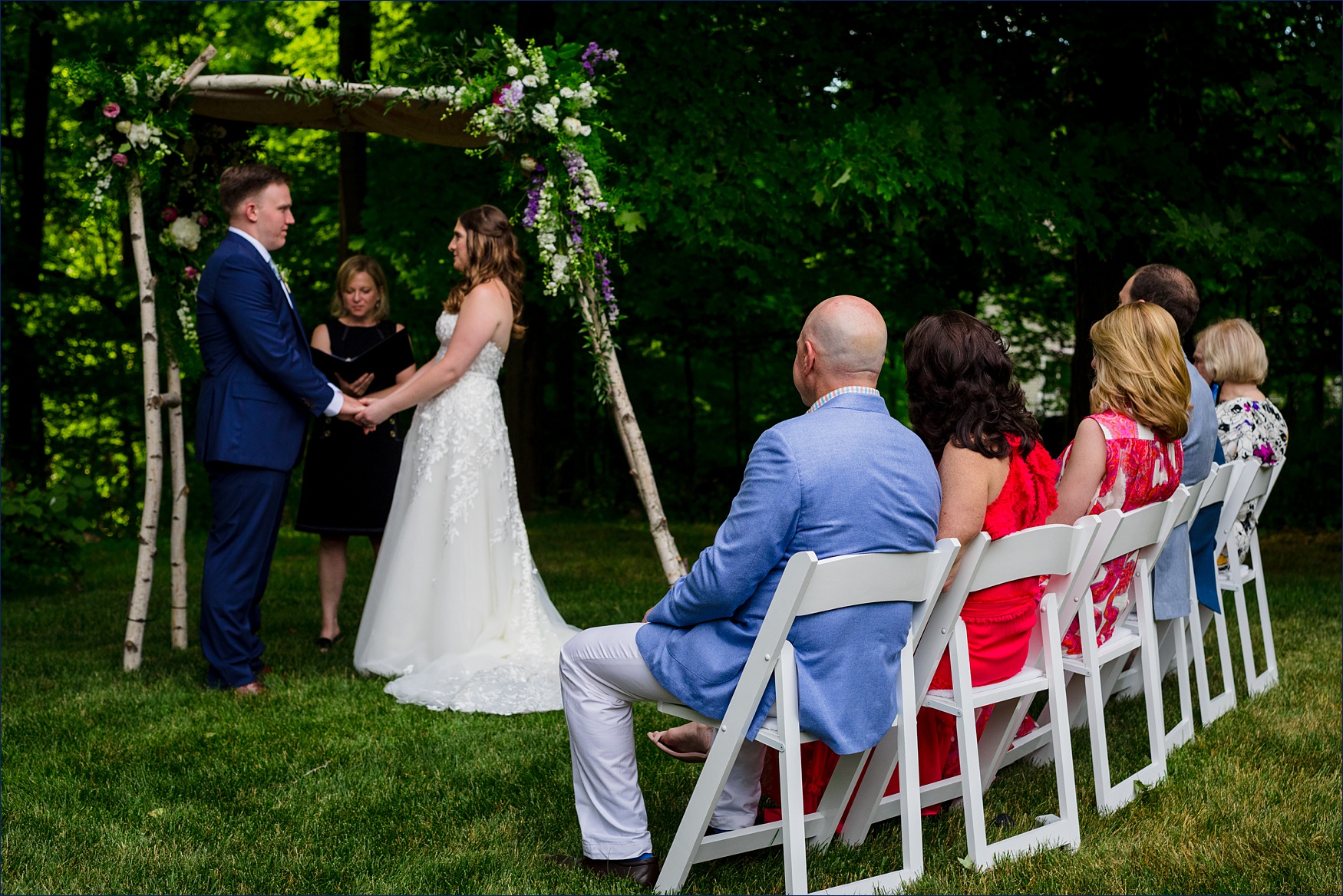 The family watches as two become one on their backyard wedding day