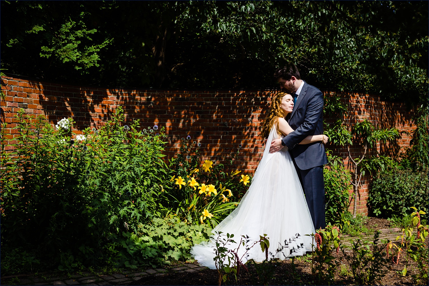 A hug in the gardens of the Stevens-Coolidge Place gardens in Andover, MA for a backyard wedding