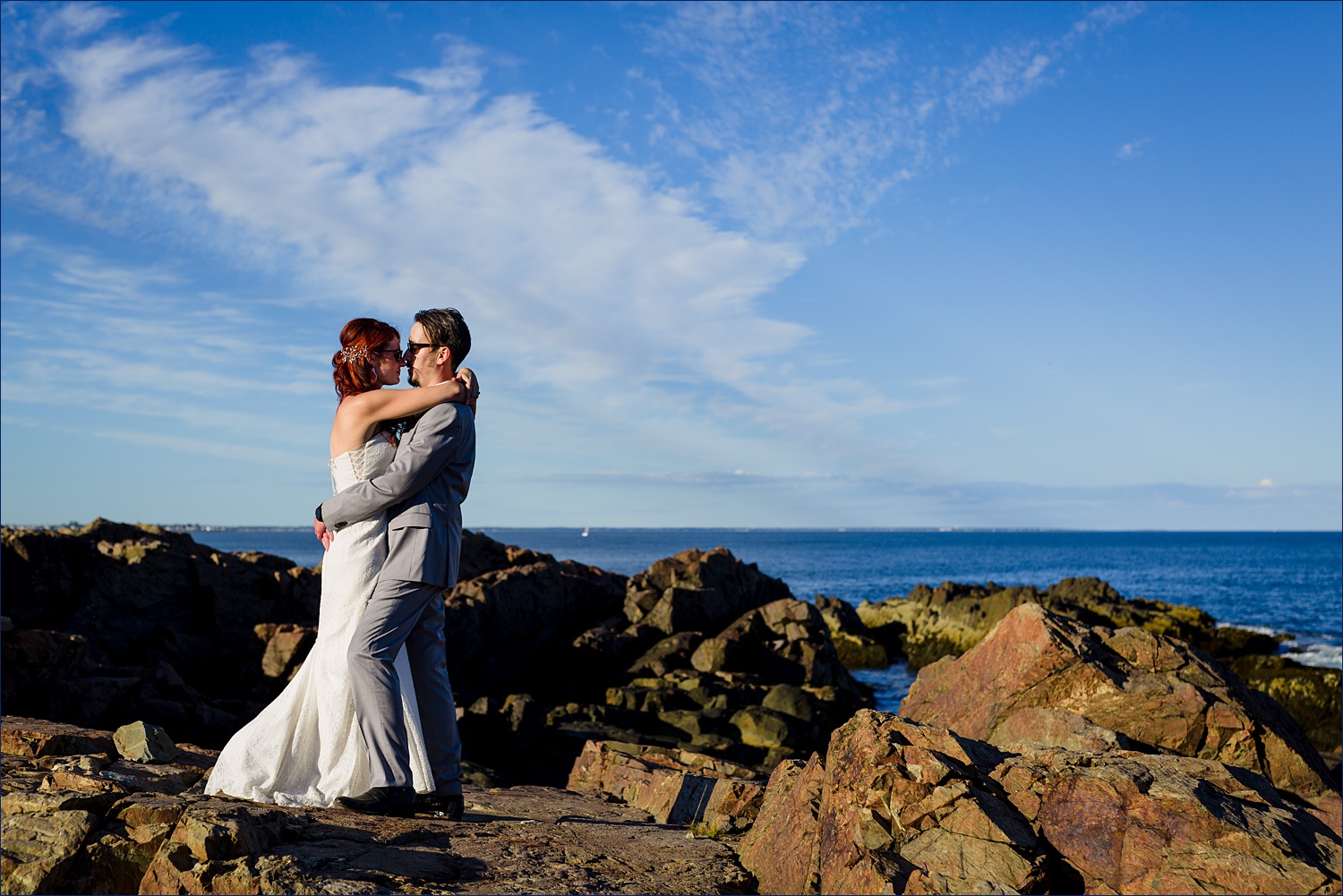The bride and groom kiss out on the rocks of Ogunquit Maine elopement