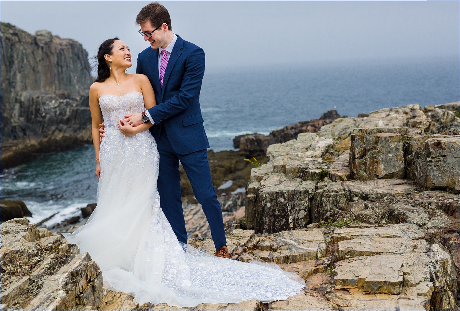 Bride and Groom cuddle in close while the fog rolls around at Cliff House in Cape Neddick
