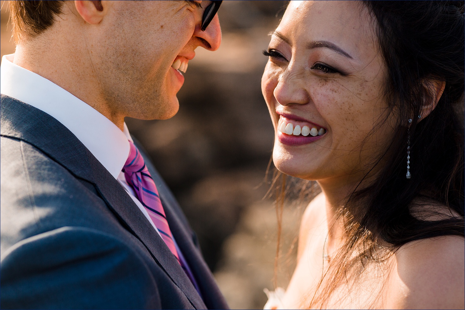 The newlyweds laugh in the golden sunlight at the Cliff House on their wedding day