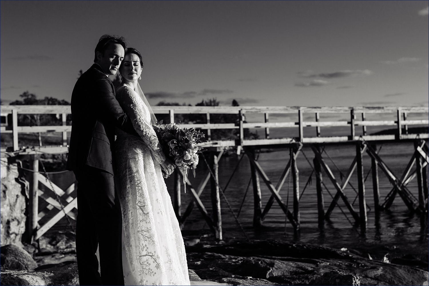The newlyweds stand in front of the dock of Spruce Point Inn Resort in Midcoast Maine on their intimate wedding day