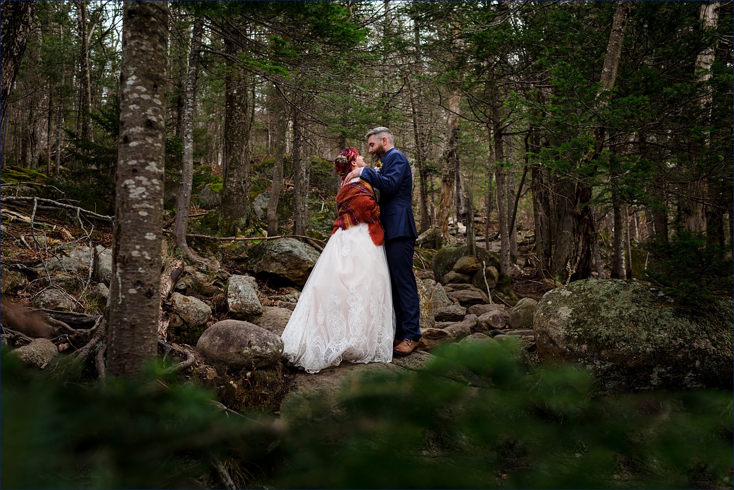 The elopement couple hold each other tight out in the woods of Gorham, NH