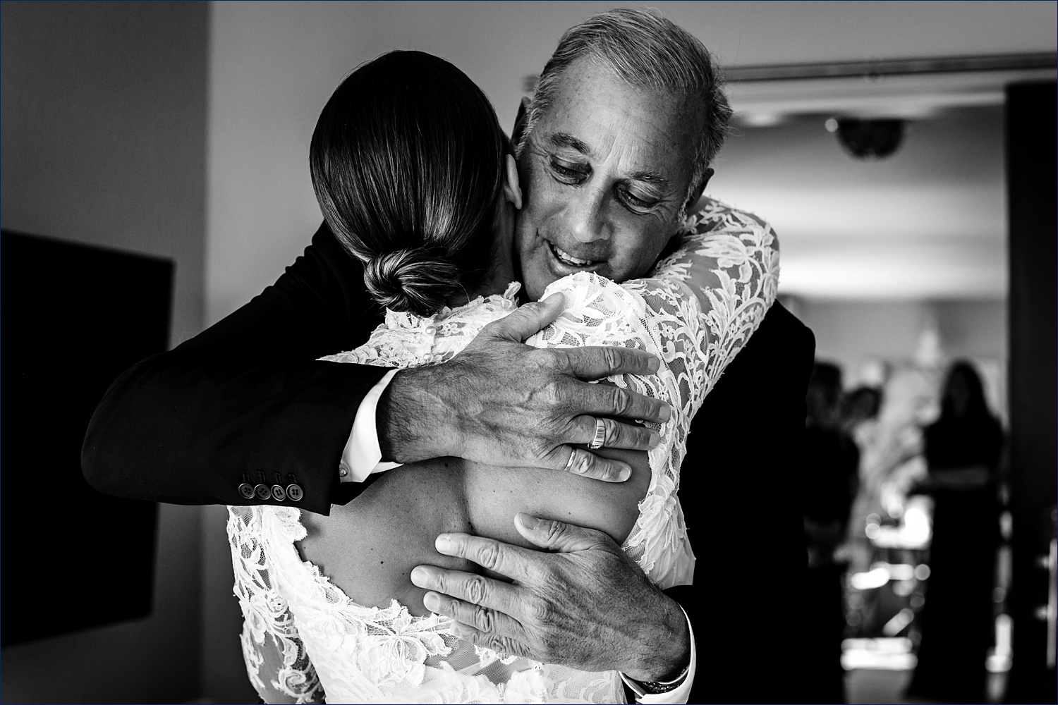 The bride hugs her father tight when he sees her for the first time on her wedding day
