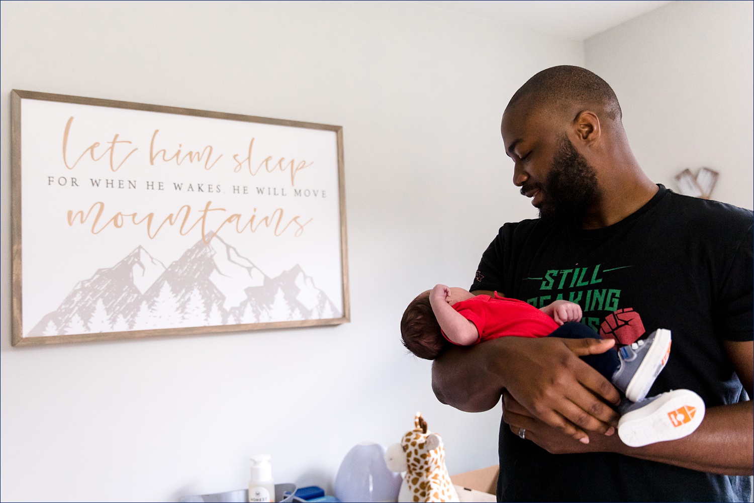 Dad holds his newborn son and marvels at him in his room in seacoast New Hampshire