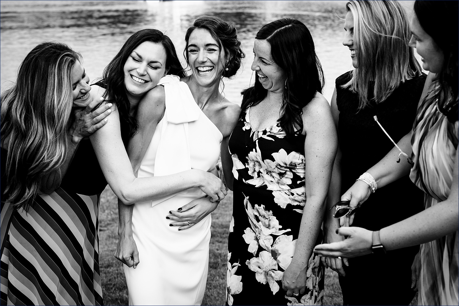 The bride and her best friends hug each other tight in celebration of her wedding day