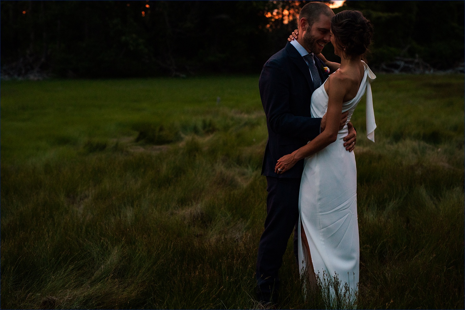 The wedding couple hold each other close on their Dockside Guest Quarters Maine wedding day in the seagrass