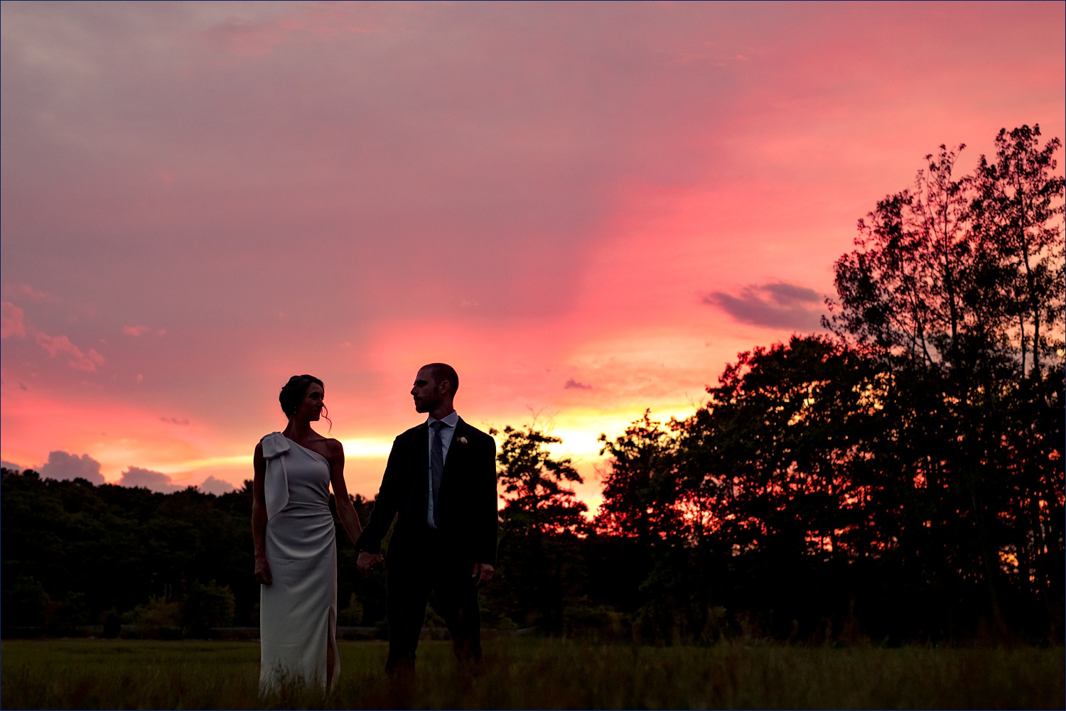 Silhouetted Couple against the pink sunset from their wedding