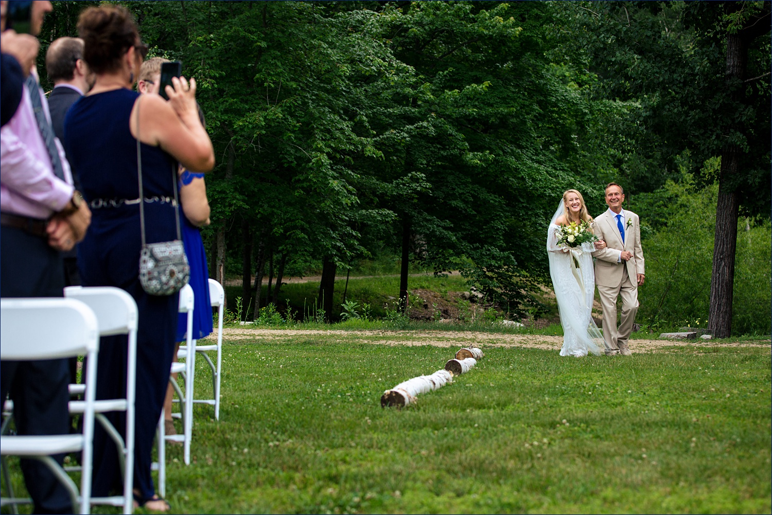 The bride and her father enter the wedding ceremony in wooded Windham NH