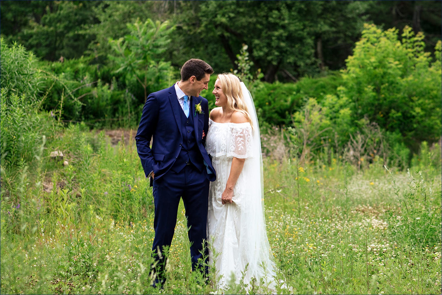 A wildflower field and the newlyweds smiling at their NH wedding day