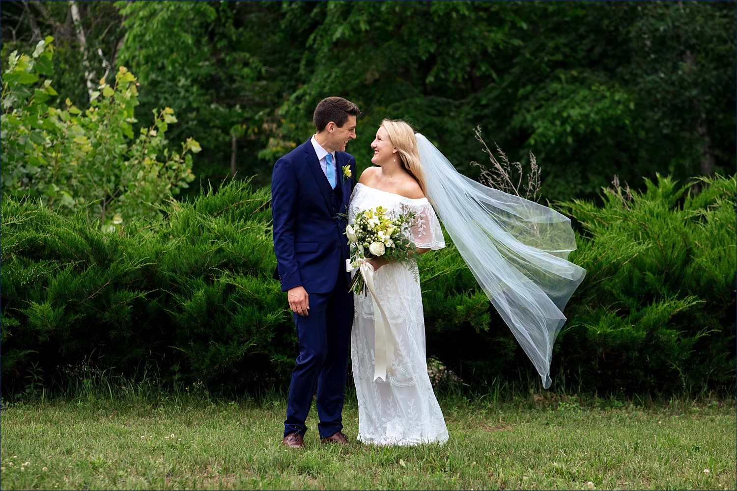 The couple with the wind and all the smiles on their New Hampshire wedding day