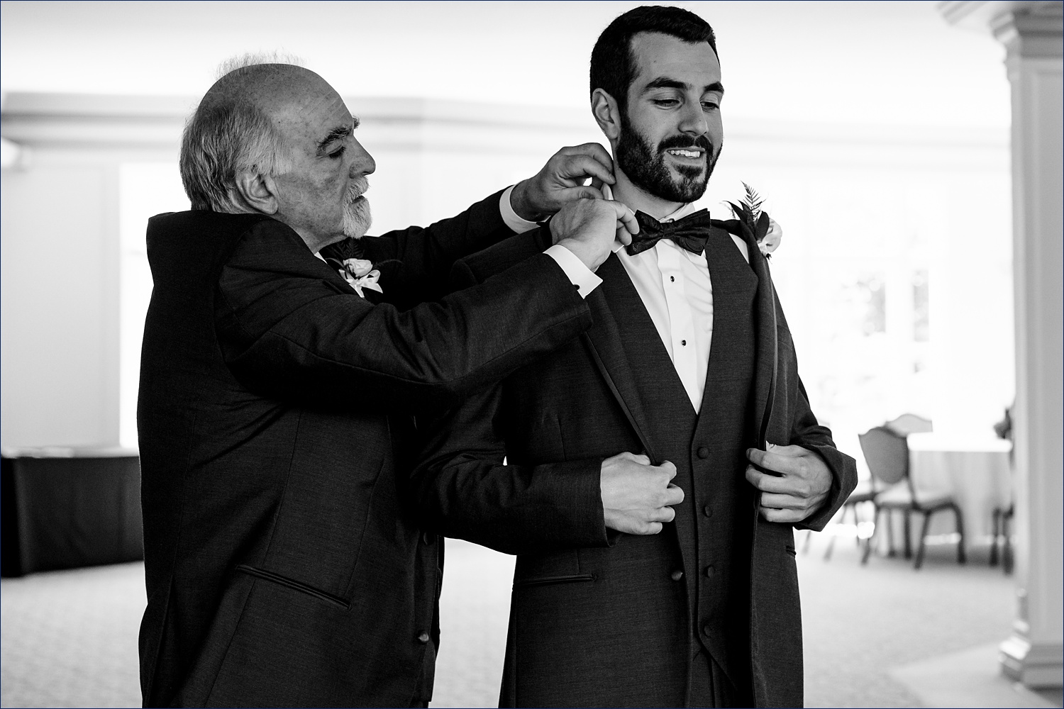 The groom gets a little help from his dad getting his bow tie fixed