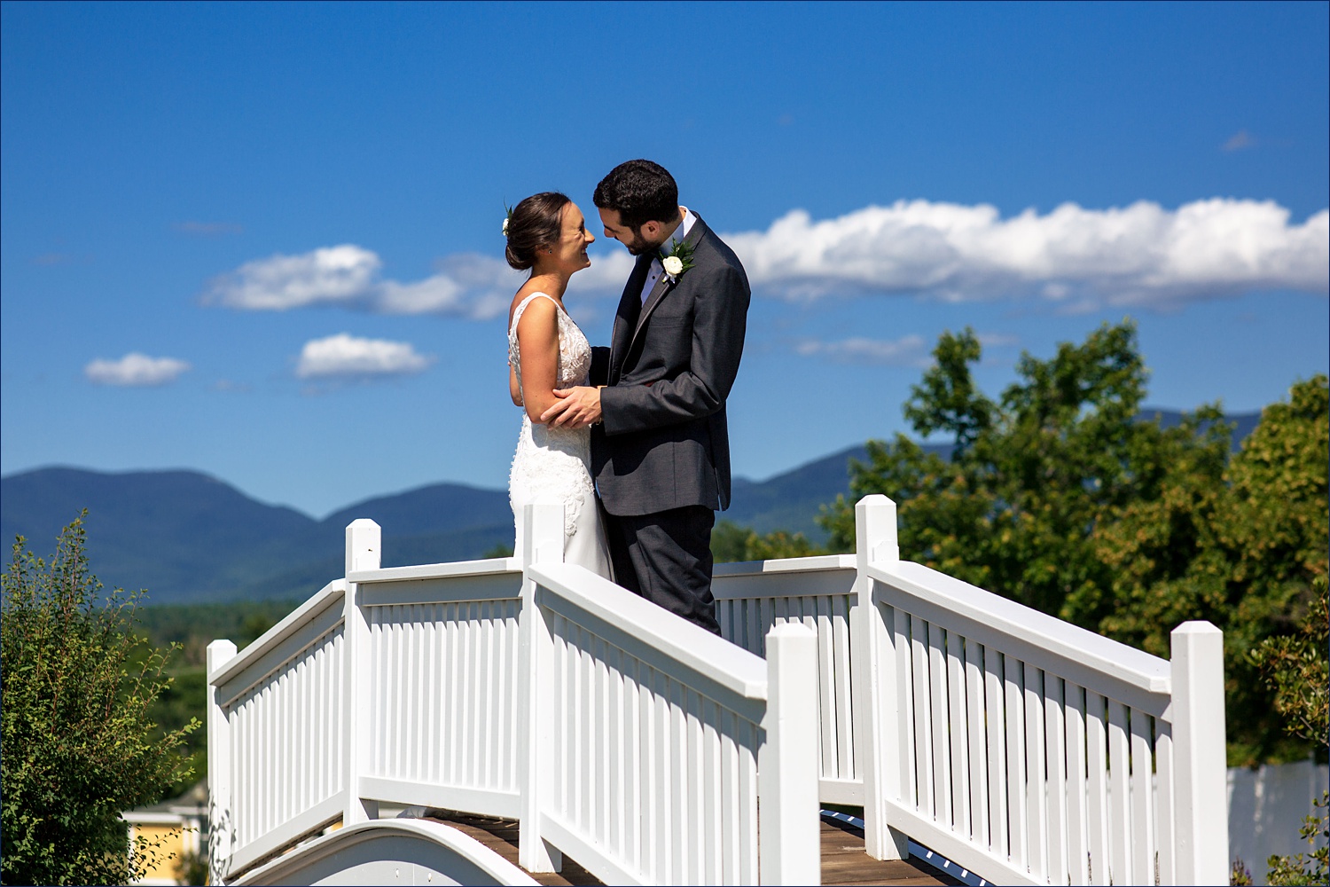 The bride and groom can't hold in their laughter on the bridge at Mountain View Grand Resort