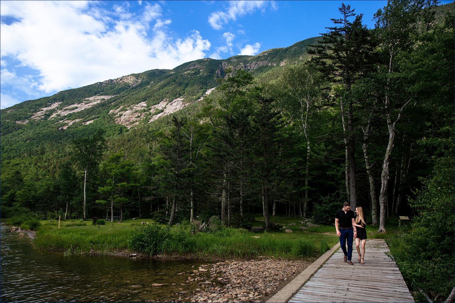 The couple walk across a wood bridge by Willey House in Crawford Notch
