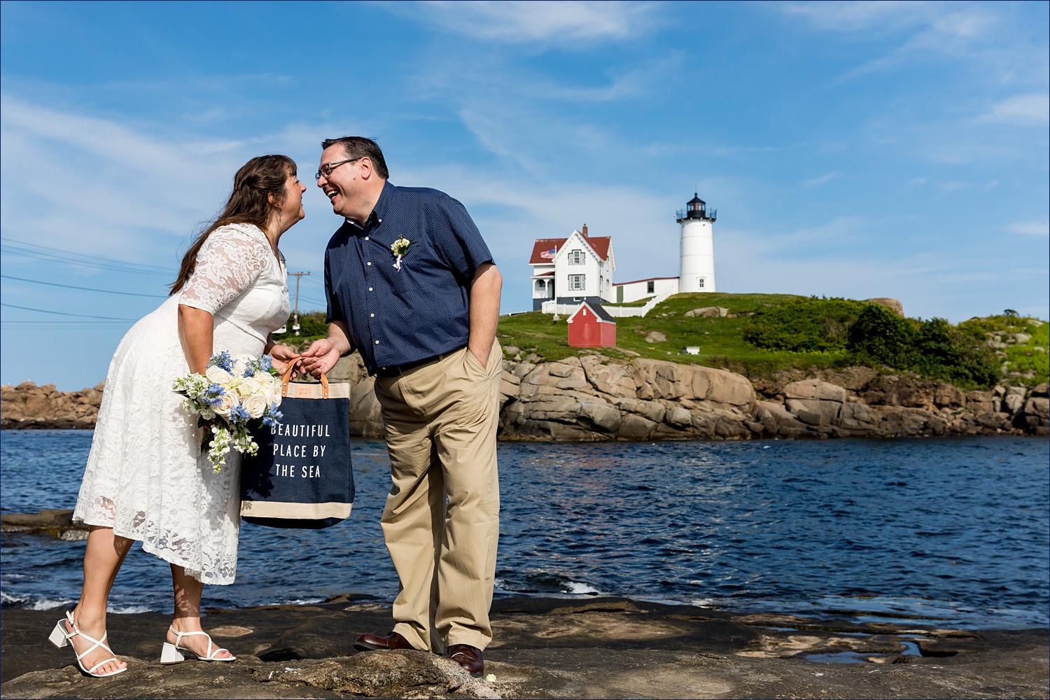 Leaning in for a kiss in front of the Nubble Light in York Maine