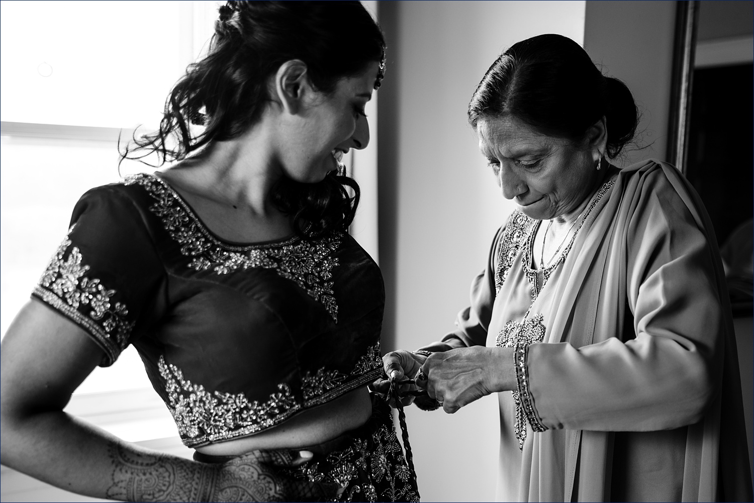 The bride's mother helps her get into her Hindu wedding attire in New Hampshire