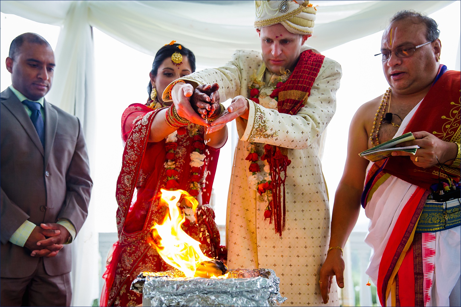 Saat Phere and Laja Homa putting rice in the ceremonial fire for the Hindu wedding in NH