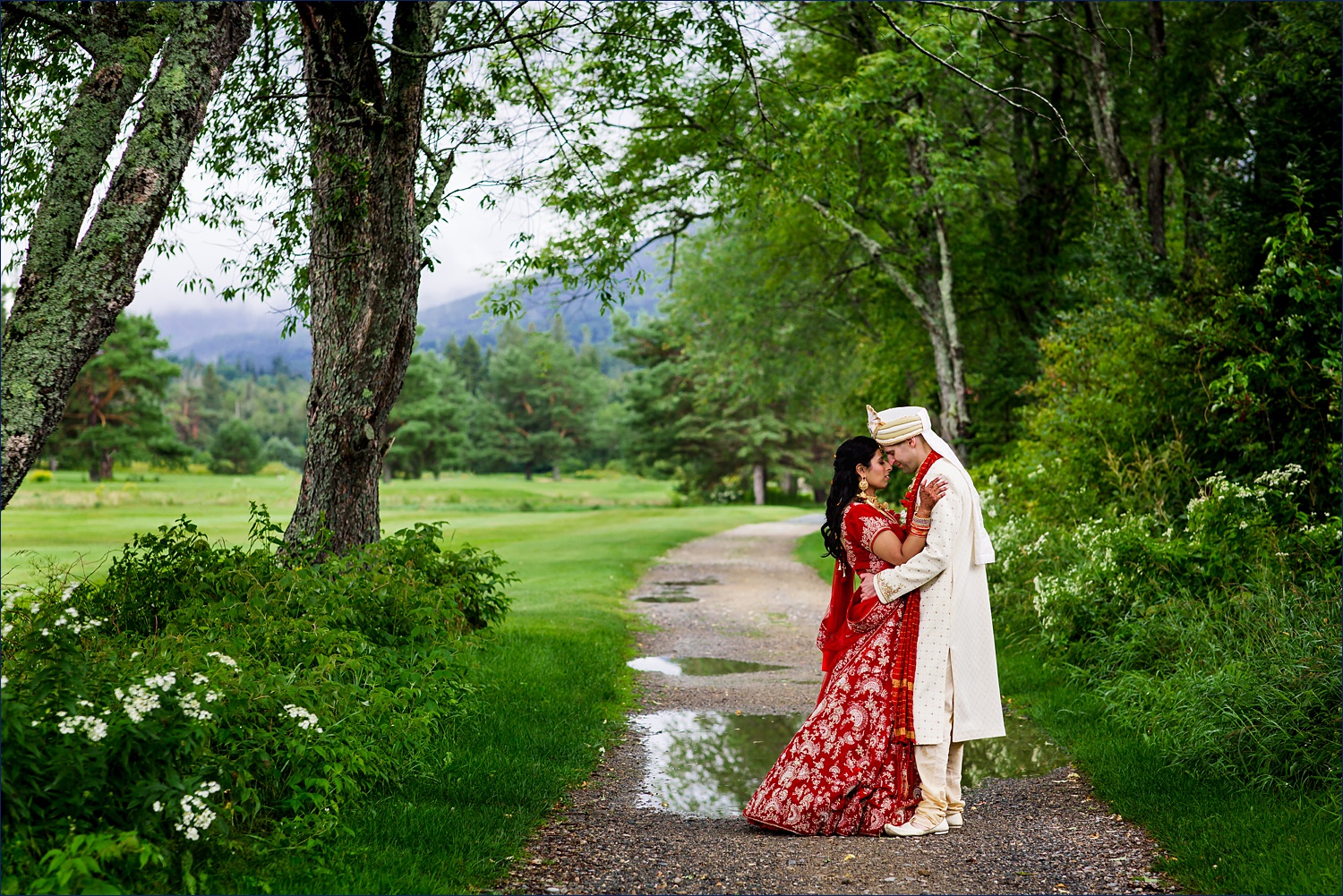 The couple stands together under a tree canopy on their White Mountain Hindu wedding day
