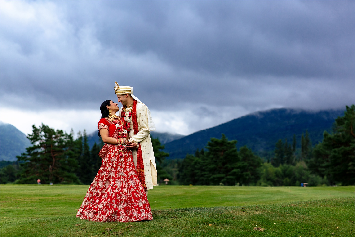 The newlyweds stand together in front of the White Mountains on their wedding day