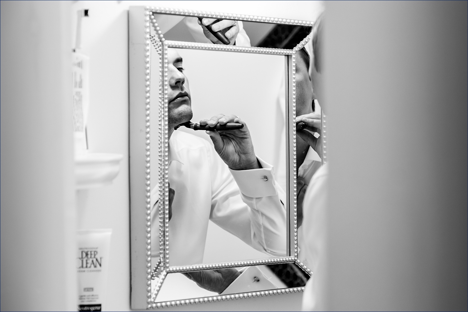 The groom does a last minute shave on his wedding day