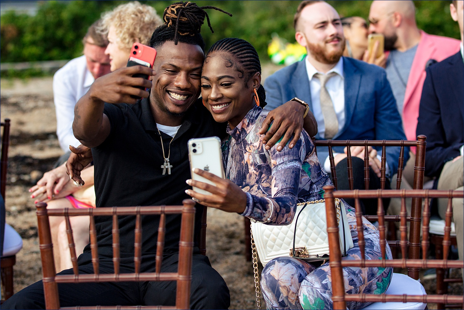 Guests take selfies while waiting for the beach ceremony to begin