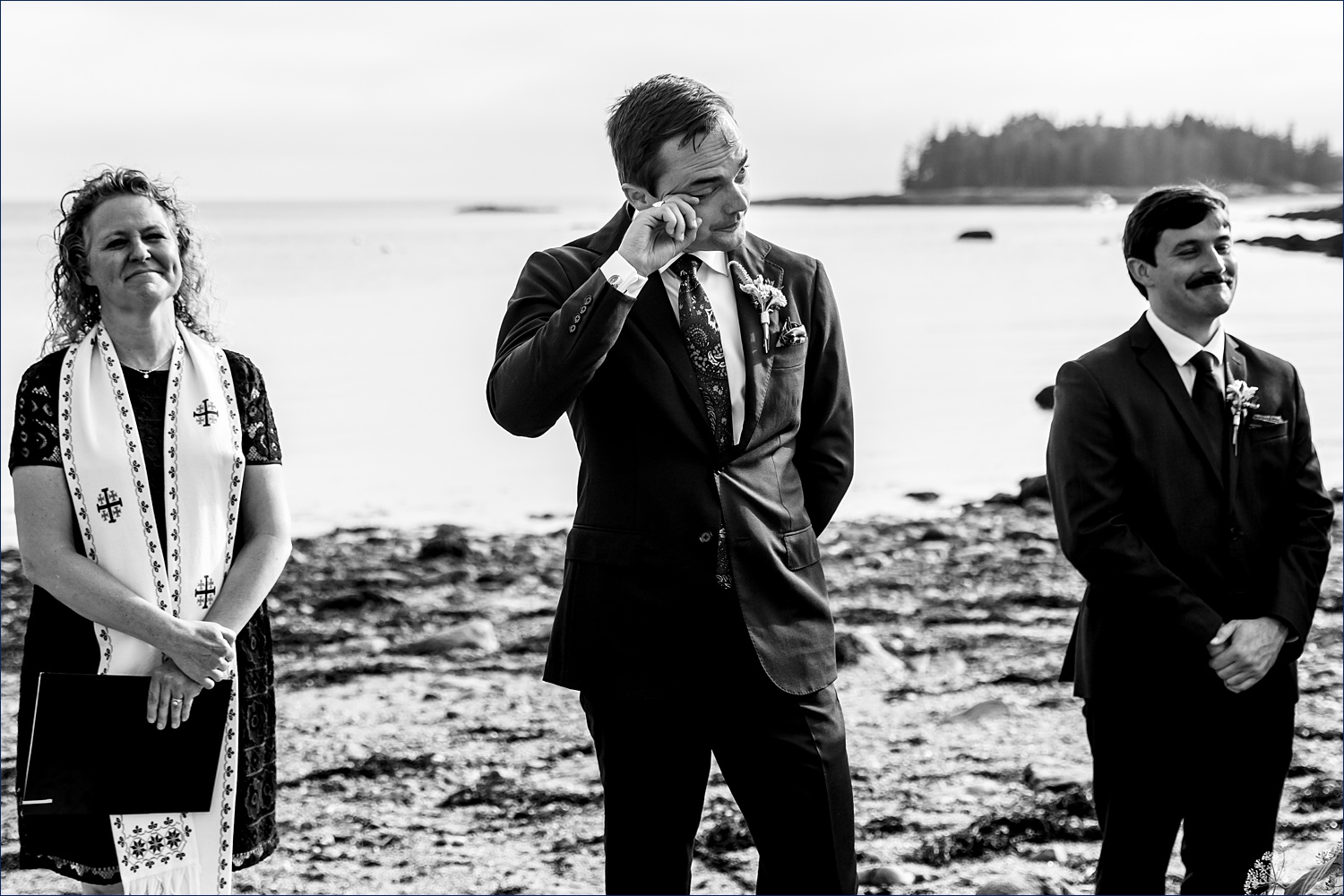 The groom tears up as the bride and her father come down the aisle on his wedding day on Deer Isle Maine