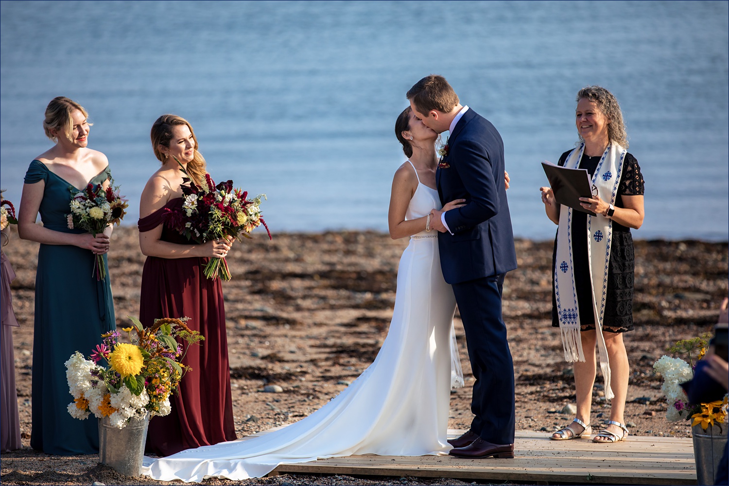 The married couple kisses on their Maine wedding day ceremony