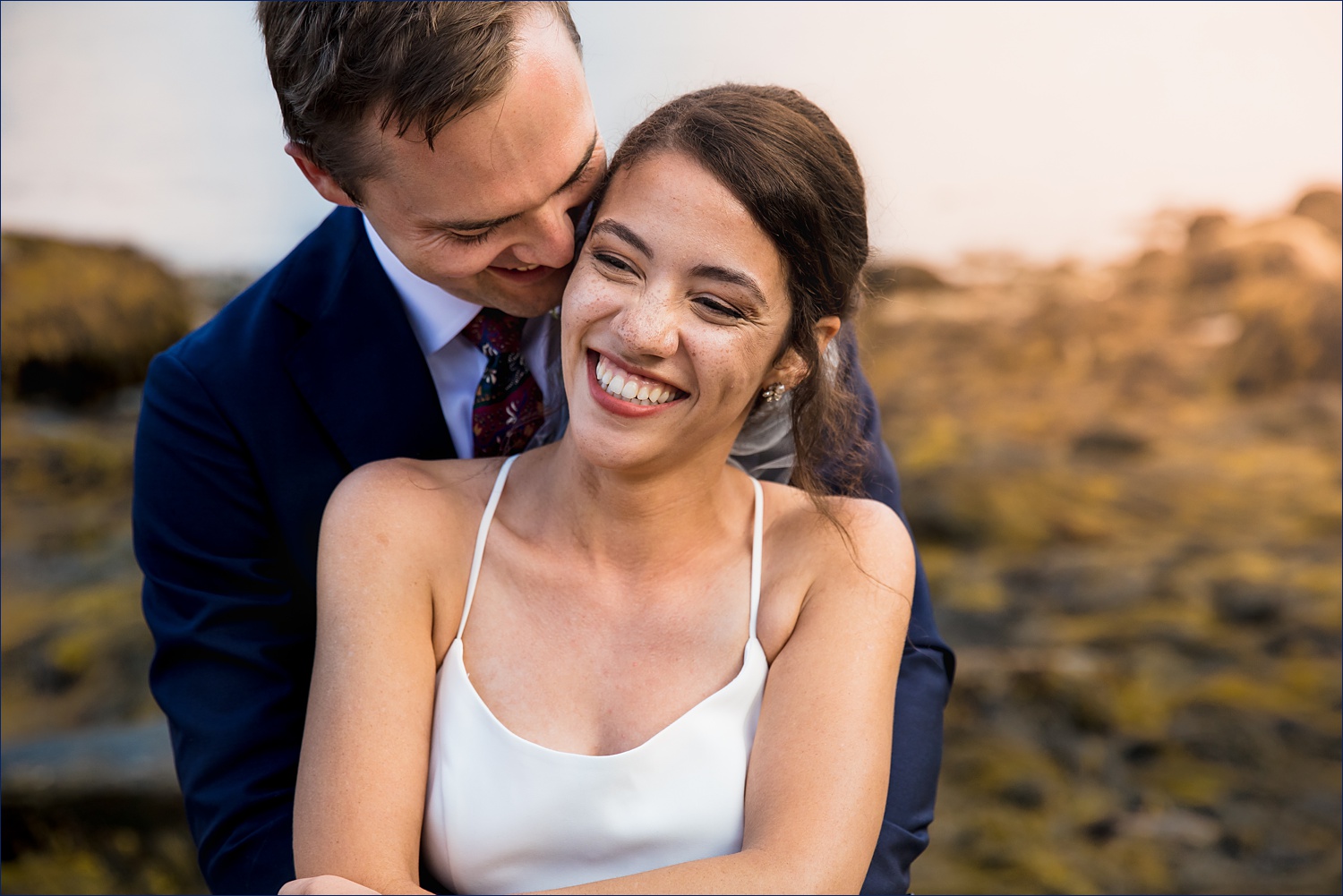 The couple laughs and hold each other close on their Deer Isle Maine wedding day