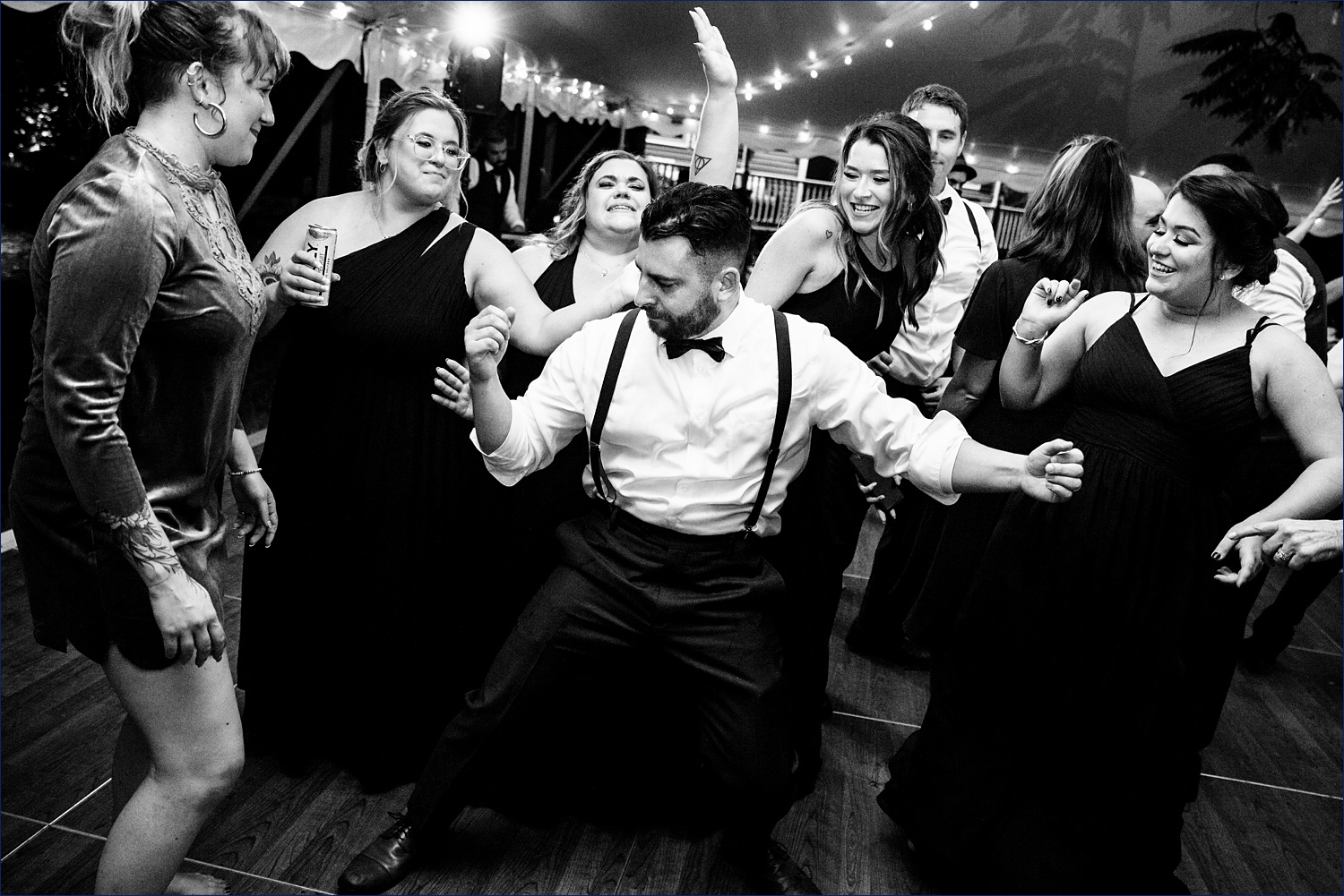 The groom parties with the bridesmaids on the dance floor