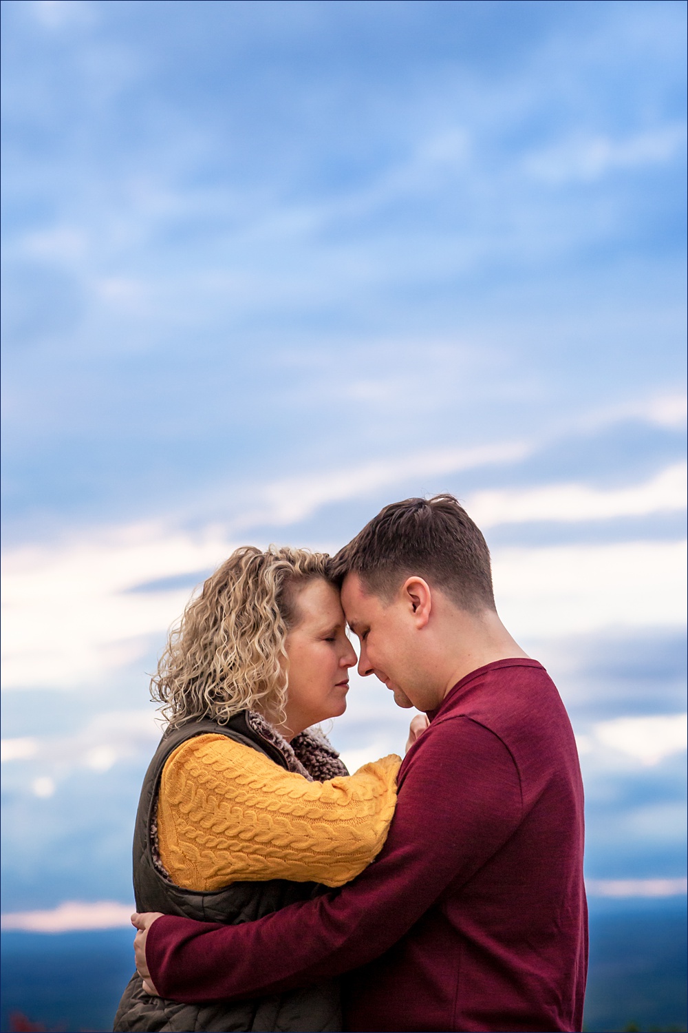 The couple and the stormy sky at their Mount Agamenticus in York Maine engagement session