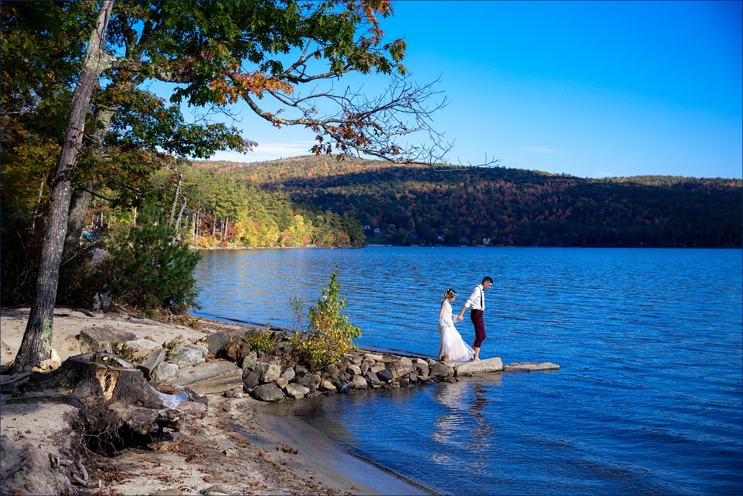 Leading the bride out on the rocks at Newfound Lake NH for fall elopement